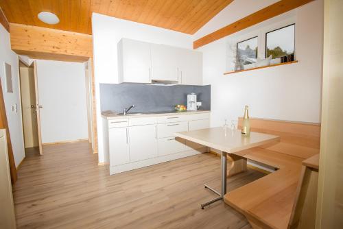 a kitchen with white cabinets and a wooden floor at Ferienwohnung Aichem in Radolfzell am Bodensee