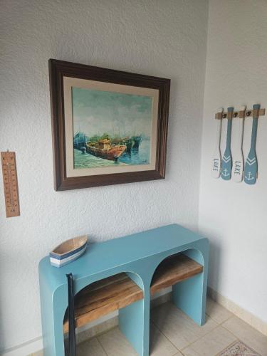a blue table in a room with a painting on the wall at Villa Adriana v rezidencii Toscamar in Jávea