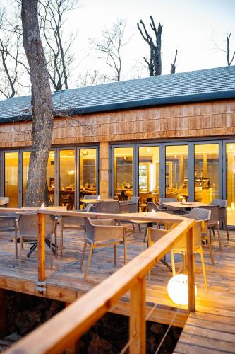 a restaurant with tables and chairs on a wooden deck at Pazar Homes in Zánka