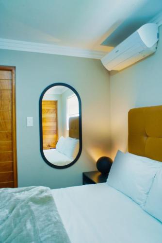 a bedroom with a bed and a mirror at Cosy Corner Sandton in Vosburg