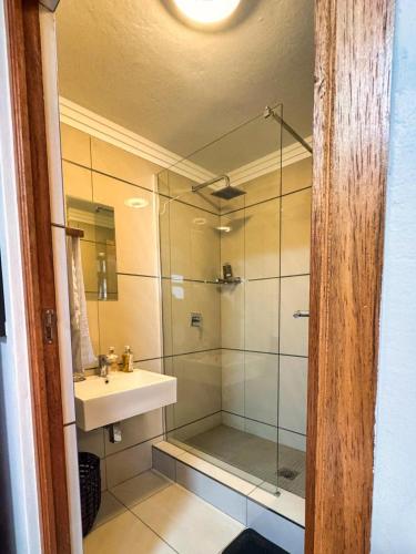 a bathroom with a glass shower and a sink at Cosy Corner Sandton in Vosburg