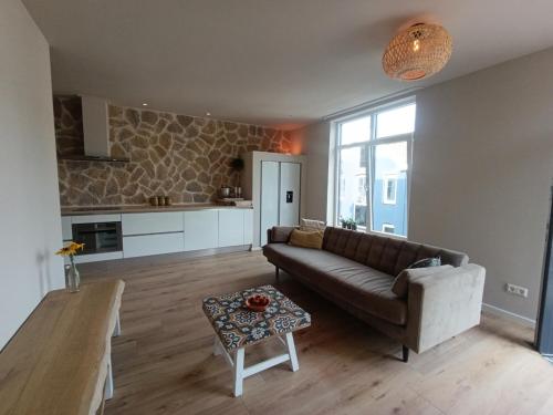 a living room with a couch and a table at Mediterranean apartment with home theater in Bodegraven