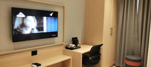 Una televisión o centro de entretenimiento en The Citi Residenci Hotel, Bidhannagar