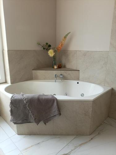 a white bath tub in a bathroom with at Mediterranean apartment with home theater in Bodegraven