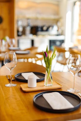a wooden table with glasses and a vase with a flower in it at Pazar Homes in Zánka