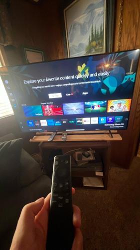 a person holding a remote control in front of a television at Agate Bay Ranch in Carnelian Bay