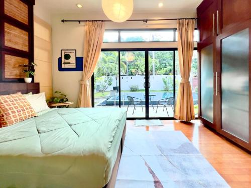 a bedroom with a bed and a sliding glass door at MYSA House Pool Villa Central Phuket in Phuket