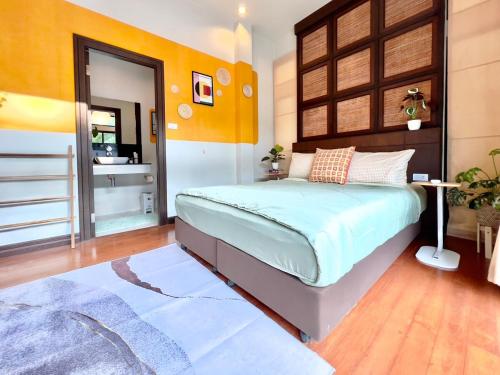 a bedroom with a large bed and a mirror at MYSA House Pool Villa Central Phuket in Phuket