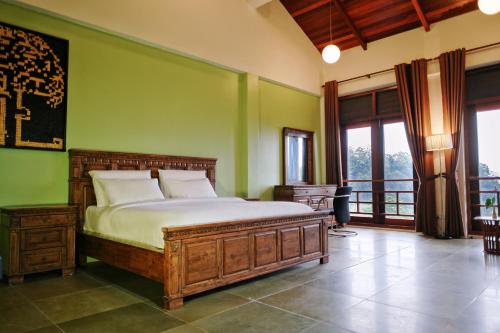 a bedroom with a bed and a green wall at Harmony Valley Retreat in Bukit Tinggi