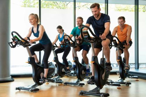 a group of people riding on exercise bikes in a gym at Sheraton Grand Hotel & Spa in Edinburgh