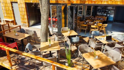 a restaurant with wooden tables and chairs and a tree at Pazar Homes in Zánka