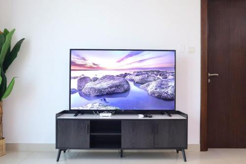 a flat screen tv sitting on a wall at Modern Haven 1BR - Peaceful & Stylish Escape in Abu Dhabi