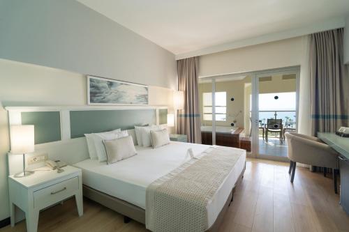 a bedroom with a large white bed and a desk at Arcanus Hotels Sorgun - Ultra All Inclusive in Side