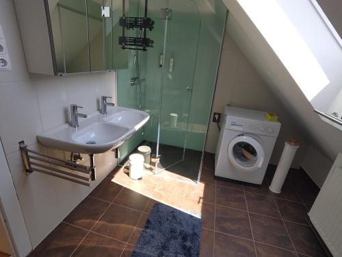 a bathroom with a sink and a washing machine at Apartment Altes Kino in Sitzenberg