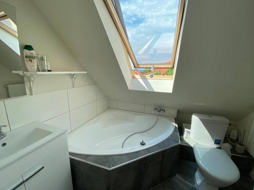 bagno con vasca, servizi igienici e finestra di Ravenswood Cottage a Balatonfůzfő