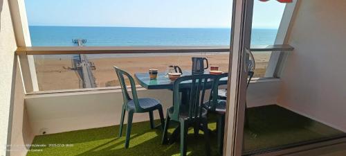 a table and chairs with a view of the beach at Très bel appartement accès direct sur plage, vue sur mer - 2 pièces - 4 pers in Saint-Jean-de-Monts