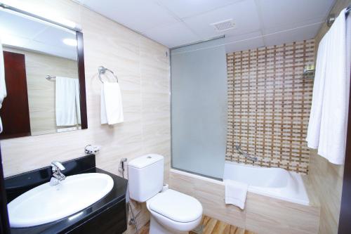 La salle de bains est pourvue de toilettes, d'un lavabo et d'une baignoire. dans l'établissement Royal Falcon Hotel, à Dubaï