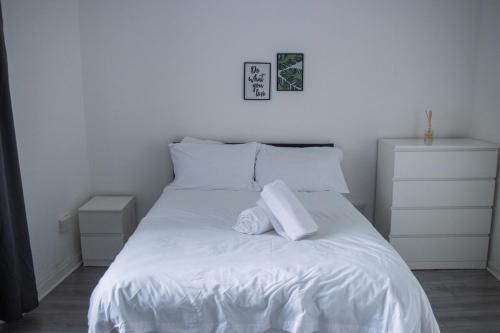 スウォンジーにあるCity Centre 6-Bed Swansea Getawayの白いベッドとタオルが2枚置かれた寝室