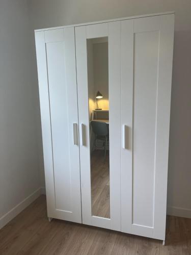 a white cabinet with a mirror in a room at Appartement neuf et cosy au coeur des vallées in Pierrefitte-Nestalas