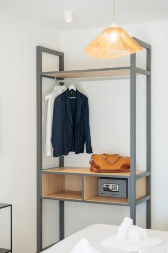 a shelf with a jacket and a jacket and a lamp at Hotel Moresco in Diano Marina