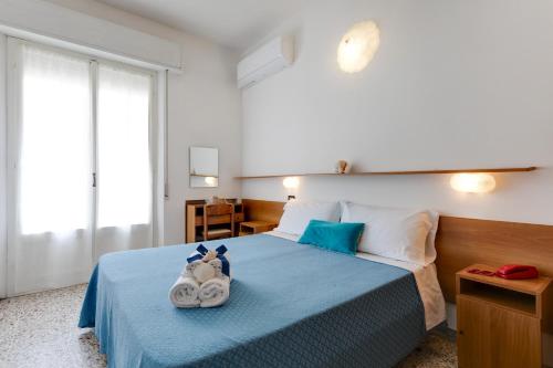 una camera da letto con un letto blu con asciugamani sopra di Hotel Numi a Rimini
