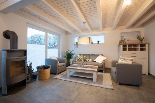 a living room with couches and a table and a fireplace at VechteSonne - Nordhorn in Nordhorn