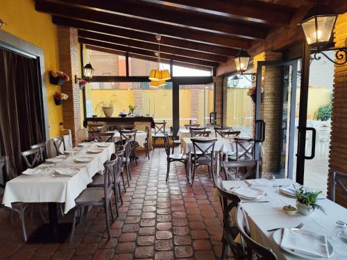 a restaurant with white tables and chairs in a room at Green Hotel Poggio Regillo in Frascati