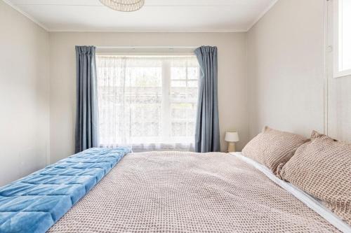 a bedroom with a large bed and a window at Home away from home 4 bedroom 2 bathrooms in Upper Hutt