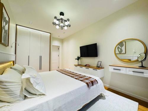 una camera da letto con un grande letto bianco e uno specchio di Бульвар Резиденция вид на парк a Tashkent