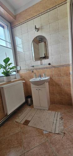 a bathroom with a sink and a mirror at Apartament 2 pokojowy z widokiem na morze in Sarbinowo