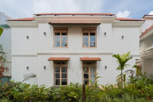a white house with four windows on it at Tranquil Trails- Amayah Neer 3-BHK Villa Near Assagao in Assagao