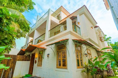 a large white house with a balcony at Tranquil Trails- Amayah Neer 3-BHK Villa Near Assagao in Assagao