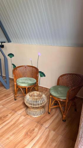 two chairs and a table in a room at Huts And Hunters Resort Saputara in Saputara