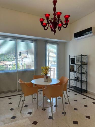 Un comedor con una mesa y sillas y una lámpara de araña. en Maison Lumiere 2-BD, en Beirut