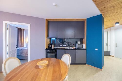 a kitchen and dining room with a wooden table at Go-Gudauri The Atrium Residence in Gudauri