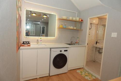 a bathroom with a sink and a washing machine at Na's Homestay Hải Phòng in Hai Phong