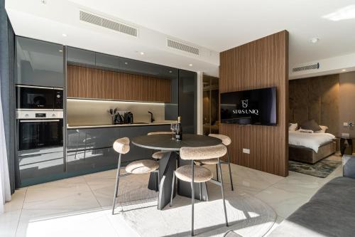 a kitchen and living room with a table and chairs at Mercury Suite Designer Apartment with Pool Access in St Julian's