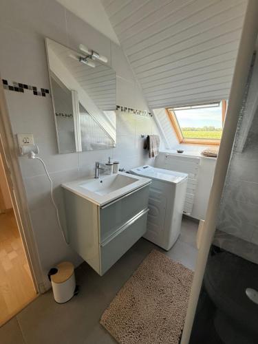 a white bathroom with a sink and a mirror at Ty benalo in Ploeren