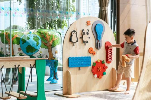 a young boy playing with a wooden play set at JW Marriott Hotel Hanoi in Hanoi