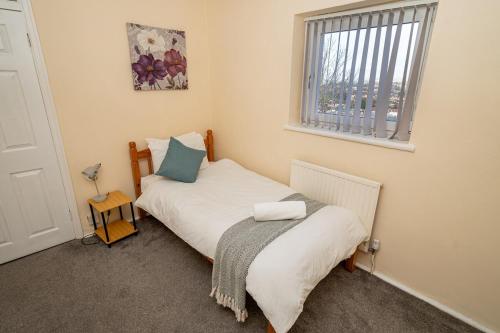 Ένα ή περισσότερα κρεβάτια σε δωμάτιο στο Comfortable 4-Bed Home with Free Parking