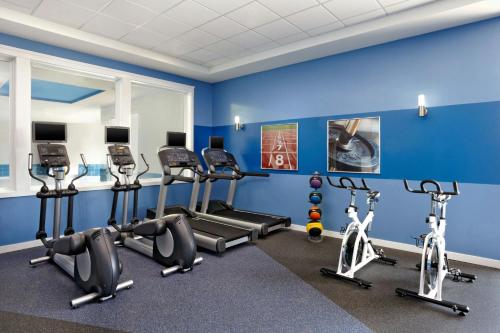 a gym with cardio equipment in a blue wall at Four Points by Sheraton Edmonton Gateway in Edmonton