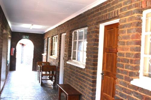 a brick hallway with a brick wall and a door at Delion Lodge in Koster