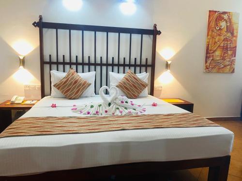 a bedroom with a bed with a swan on it at The Long Beach Resort & Spa in Koggala