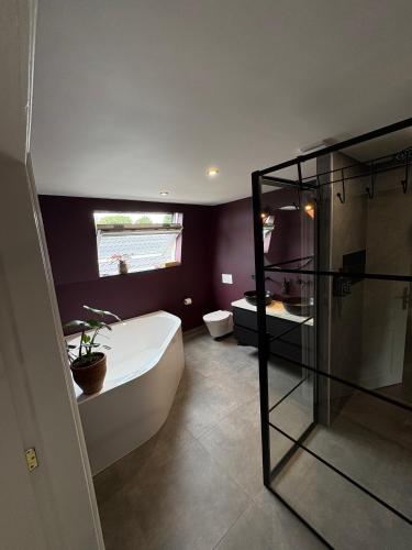 a bathroom with a tub and a shower and a toilet at Maastrichtse buitenwoning in Cadier en Keer