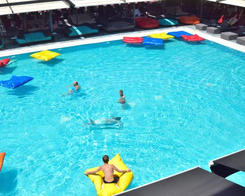 a group of people in a large swimming pool at Sea View Serenity Βeachfront & Pool 105 in Salamís