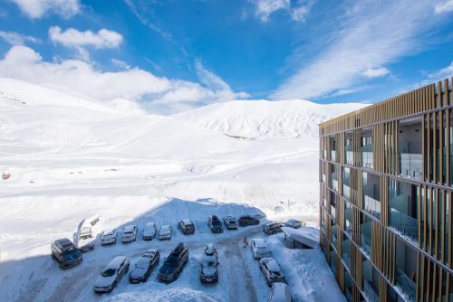 a group of cars parked in a parking lot in the snow at Go-Gudauri The Atrium Residence in Gudauri