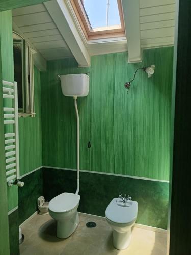 a green bathroom with a toilet and a sink at Guest house SAL E PEDRA in Villanueva de Arosa