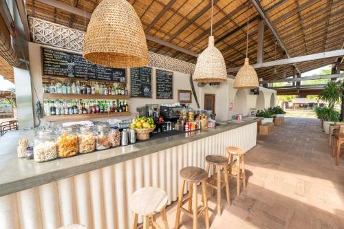 a restaurant with a bar with stools and drinks at Wake Park Cambodia in Siem Reap