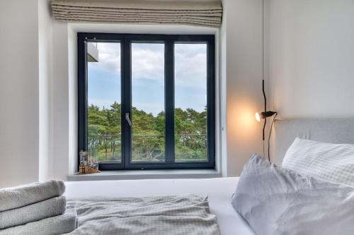 ein Schlafzimmer mit einem Bett und einem Fenster mit Aussicht in der Unterkunft Ferienwohnung Strandloft 12 im Haus Düne 7 Prora in Binz