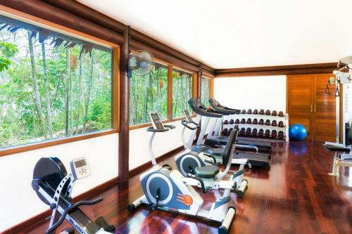 a gym with treadmills and ellipticals in a room with windows at Sheraton Samoa Beach Resort in Mulifanua